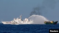 资料照：中国海岸警卫队在第二托马斯礁附近向菲律宾执行补给任务的民用船只发射水炮。（2024年3月5日）
