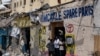 Sejumlah warga tampak berada di pintu masuk sebuah gedung yang hancur akibat serangan yang dilancarkan oleh kelompok militan Al-Shabab di Mogadishu, Somalia, pada 21 Agustus 2022. (Foto: AFP/Hassan Ali Elmi)