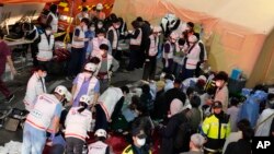 Petugas penyelamat merawat orang yang terluka di jalan dekat lokasi kejadian di Seoul, Korea Selatan, 30 Oktober 2022. (Foto: AP)