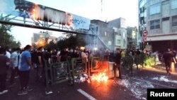 Demonstrators light a fire during a protest over the death of Mahsa Amini while in custody of Iran's morality police, in Tehran, Sept. 21, 2022. (West Asia News Agency via Reuters)