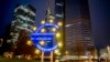 FILE - A man walks past the Euro sculpture in Frankfurt, Germany, March 11, 2021. 