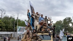Para anggota pasukan Taliban merayakan satu tahun kembalinya kelompok tersebut berkuasa di Afghanistan dalam sebuah aksi di depan kantor Kedutaan Besar AS di Kabul, Afghanistan, pada 15 Agustus 2022. (Foto: AP/Ebrahim Noroozi)