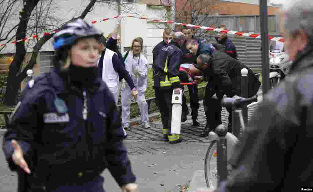 Firefighters carry a victim on a stretcher at the scene after a shooting at the Paris offices of Charlie Hebdo, a satirical weekly paper, Jan. 7, 2015.