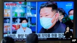 Publik menonton layar TV yang menampilkan program berita yang melaporkan pemimpin Korea Utara Kim Jong Un, di sebuah stasiun kereta api di Seoul, Korea Selatan pada 16 Mei 2022. (Foto: AP)