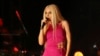 FILE - Turkish pop star Gulsen performs in Aydin, Turkey, March 27, 2022. A Turkish court on Aug. 29, 2022, released Gulsen from jail but placed her on house arrest to await trial on charges of “inciting hatred and enmity” for a joke she made about Turkey's religious schools. 