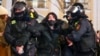 Police officers detain a woman in St. Petersburg, Russia, Feb. 25, 2022. 