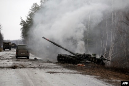 Dim se diže iz ruskog tenka koji su uništile ukrajinske snage pored puta u regiji Lugansk, 26. februara 2022.