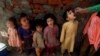 FILE - A health worker administers a polio vaccine to a child in Lahore, Pakistan, Feb. 28, 2022, as other children line up.