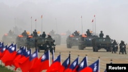 Soldiers drive their military vehicles past Taiwan flags during an army exercise in Hsinchu, central Taiwan January 27, 2010. The U.S. and China are currently at odds over an arms sales to Taiwan, according to local media. REUTERS/Nicky Loh 