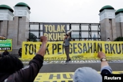 Seorang aktivis meneriakkan slogan-slogan saat protes pengesahan KUHP yang melarang seks di luar nikah, kumpul kebo di antara pasangan yang belum menikah, menghina presiden, dan mengungkapkan pandangan yang bertentangan dengan ideologi nasional, di luar gedung DPR di Jakarta, Desember 5 Tahun 2022. (Foto: REUTERS/Willy Kurniawan)
