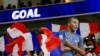 Potongan foto Kylian Mbappe dari Prancis diangkat tinggi-tinggi saat bendera Prancis dikibarkan oleh para penggemar selama pertandingan. (Foto: REUTERS/Bernadett Szabo)