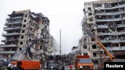 Emergency personnel work at the site where an apartment block was heavily damaged by a Russian missile strike, amid Russia's attack on Ukraine, in Dnipro, Ukraine, Jan. 15, 2023. 