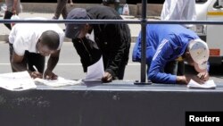 FILE - Abadabuka eZimbabwe abadinga amaphepha okuhlala lokusebenza kwele South Africa.