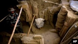 Di lembah Mes Aynak, selatan Kabul, Afghanistan, seorang arkeolog Afghanistan berdiri di samping sisa-sisa patung Buddha yang ditemukan di dalam sebuah kuil kuno, 12 Oktober 2010. (Foto: AP)