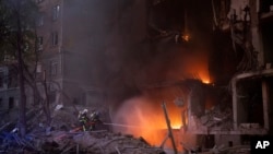 Firefighters try to put out a fire following an explosion in Kyiv, Ukraine, April 28, 2022.