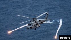 FILE PHOTO: A U.S. Navy MH-60R Sea Hawk helicopter from the "Blue Hawks" of Helicopter Maritime Strike Squadron 78 fires chaff flares during a training exercise in the Philippine on April 24, 2017. U.S. Navy/Mass Communication Specialist 2nd Class Sean M. Castellano via REUTERS 