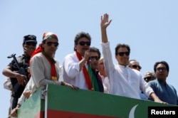 Ousted Pakistani Prime Minister Imran Khan gestures as he travels on a vehicle to lead a protest march to Islamabad, in Mardan, Pakistan, May 25, 2022.