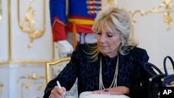 FILE - First lady Jill Biden signs a guest book during her visit with President of Slovakia Zuzana Caputova at the Presidential Palace in Bratislava, Slovakia, May 9, 2022. 