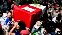 Sejumlah pria tampak membawa peti jenazah berisi mayat tentara Ahmed Mohamed Ahmed Ali, yang tewas terbunuh dalam serangan yang diklaim oleh ISIS pada 7 Mei 2022. Pemakaman tersebut dilakukan di Provinsi Qalyubia, Mesir, pada 8 Mei 2022. 