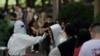 Seorang petugas kesehatan mengambil sampel swab dari seorang perempuan untuk diuji COVID-19 di tempat pengambilan swab di Beijing, 27 Mei 2022. (Foto: AFP)