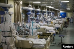 Pekerja medis dengan pakaian pelindung merawat pasien COVID-19 di unit perawatan intensif rumah sakit yang ditunjuk selama wabah COVID-19 di Wuhan, China, 6 Februari 2020. (Foto: via Reuters)