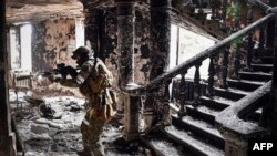 A Russian soldier patrols at the Mariupol drama theater that was bombed last March 16, in Mariupol, as Russian troops intensify a campaign to take the strategic port city, April 12, 2022.