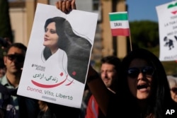 Orang-orang menggelar protes atas kematian Mahsa Amini, perempuan yang meninggal saat berada dalam tahanan polisi di Iran, saat unjuk rasa di Roma tengah, Sabtu, 29 Oktober 2022. (Foto: AP)