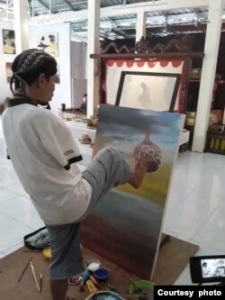 Salim melukis "Semar Anabdo Sungsang", dengan kuas di kakinya (foto: courtesy).