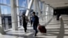 ARHIVA - Putnici nose zaštitne maske na aerodromu JFK u Njujorku (Foto: REUTERS/Shannon Stapleton)