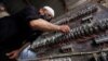 FILE - A man works on an electrical generator board during power outages in Basra, Iraq, Aug. 21, 2021. 