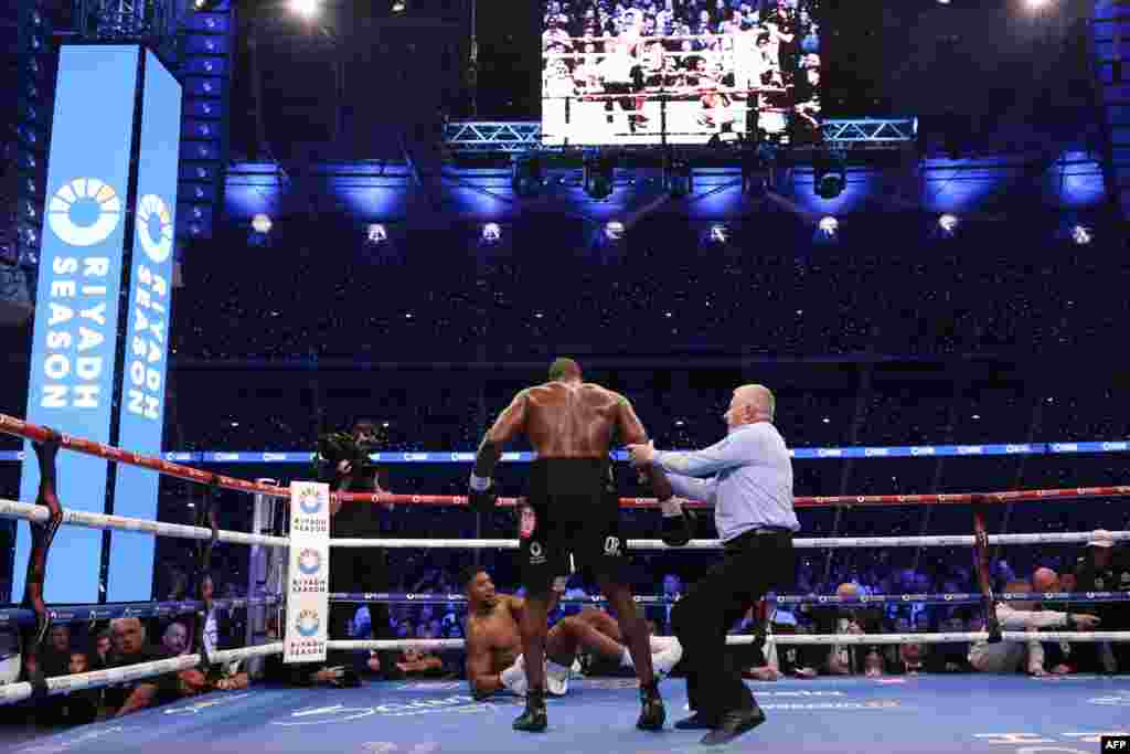 Moyi Grande-Bretagne Anthony Joshua akweyi na makofi ya moyi Grande-Bretagne mosusu Daniel Dubois na bitumba ya ba poids lourds ya nkamba ya molongo ya IBF na etando ya masano ya Wembley, Londres, Sanza 21 2024. (Photo by Adrian Dennis / AFP)