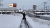 A person clears the snow from the sidewalk in Lowville, New York, Nov. 30, 2024. 