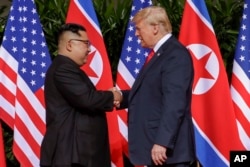 Predsednik SAD Donald Tramo rukuje se sa severnokrejskim liderom Kim Džong Unom u odmaralištu Kapela na Santosa ostrvu, 12. juna 2018. u Singapuru.