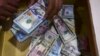 Seorang petugas penukaran uang mengumpulkan dolar AS di Karachi pada 26 Januari 2023. (Foto: AFP)