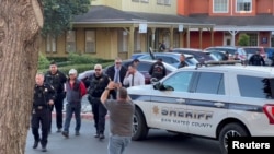 Polisi menahan seorang pria yang diyakini oleh penegak hukum sebagai tersangka penembakan massal Half Moon Bay, di Half Moon Bay, California, AS, 23 Januari 2023, dalam tangkapan layar yang diambil dari video media sosial. (Kati McHugh via REUTERS)