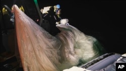 This image provided by the US Navy shows sailors assigned to Explosive Ordnance Disposal Group 2 recovering a high-altitude surveillance balloon off the coast of Myrtle Beach, SC, Feb. 5, 2023. (US Navy via AP)