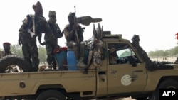Soldiers of the Chad Army sit on the back of a Land Cruiser at the Koundoul market, 25 km from N'Djamena, on Jan. 3, 2020, upon their return after a months-long mission fighting Boko Haram in Nigeria.