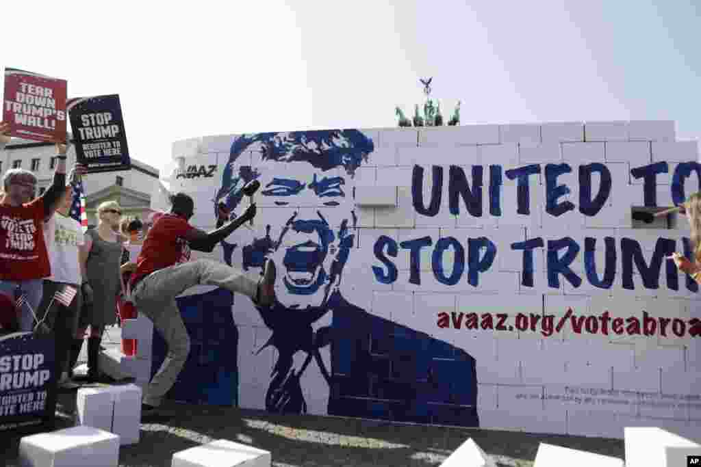 Protestors tear down a so-called &#39;Trump&#39;s wall of hate&#39; as part of a demonstration against U.S. Republican presidential candidate Donald Trump in front of the Brandenburg Gate at the Pariser Platz in Berlin, Germany.
