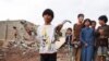 Seorang anak laki-laki tampak memegang pecahan peluru meriam dari rudal di lokasi serang yang diluncurkan oleh kelompok pemberontak Houthi di Marib, Yaman, pada 3 Oktober 2021. (Foto: Reuters/Ali Owidha)