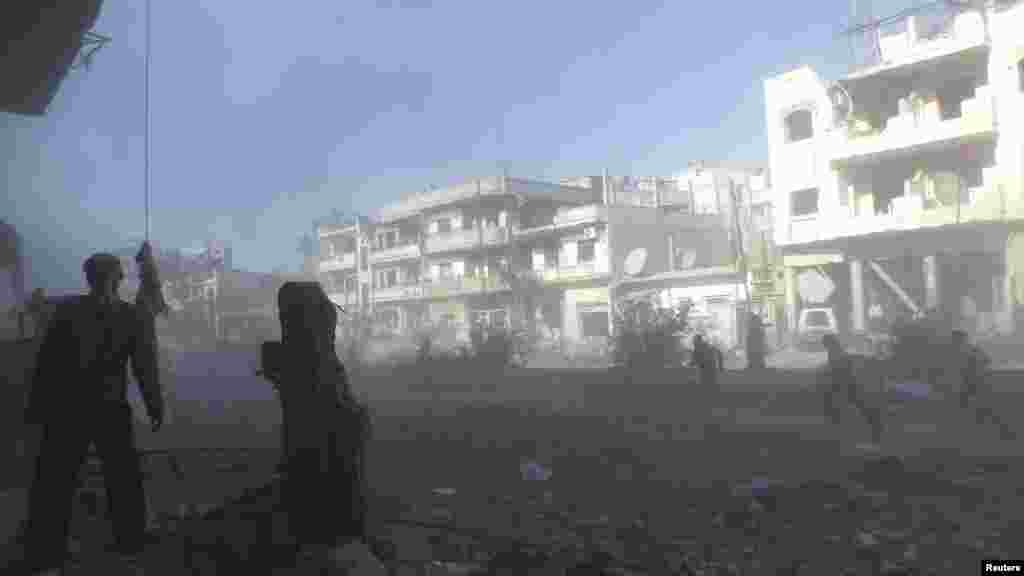 People run during shelling as people are being evacuated with the help of Syrian Red Crescent and U.N. personnel from a besieged area of Homs, Feb. 9, 2014.