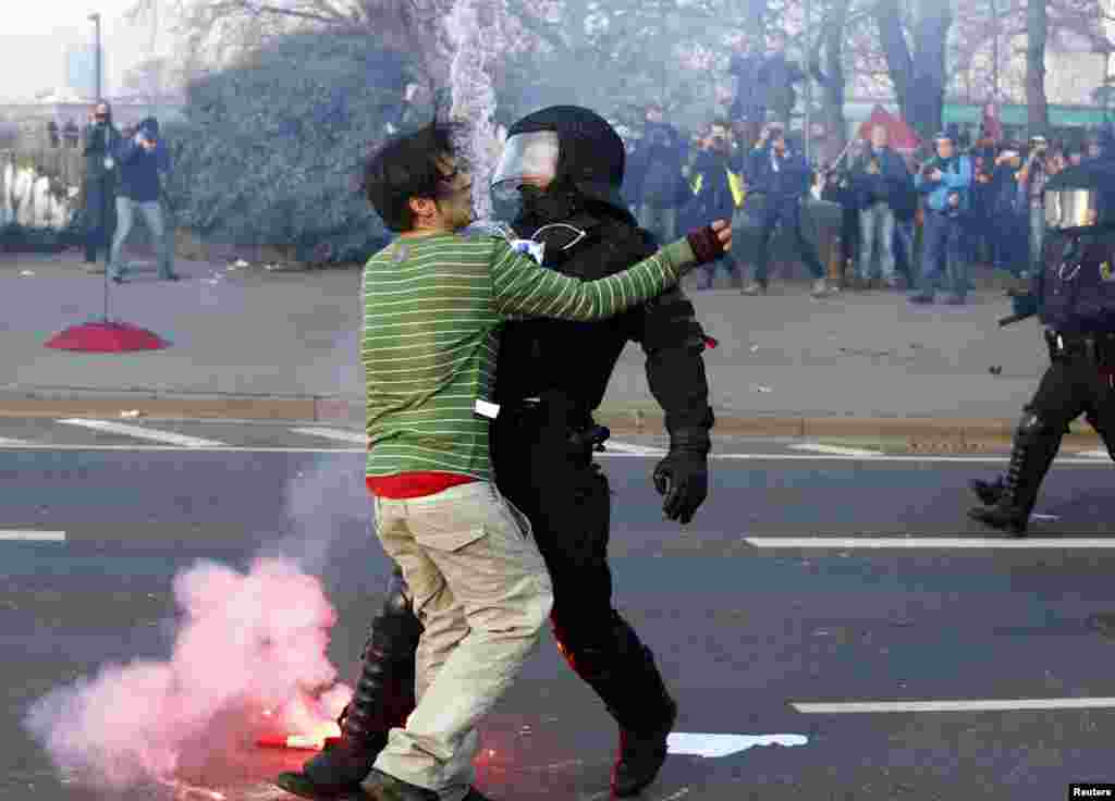 Seorang polisi memberhentikan demonstran anti-kapitalis 'Blockupy' dekat gedung Bank Sentral Eropa (ECB) sebelum pembukaan resmi markas besar barunya di Frankfurt 18 Maret 2015. (REUTERS/Michael Dalder)