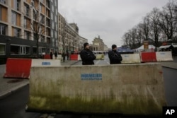 Naoružani policajci stoje ispred betonskih blokova raspoređenih oko Brandenburške kapije u Berlinu