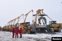 FILE - Workers of China National Petroleum Corp. are seen at a construction site of natural gas pipelines connecting China and Russia, in Heihe, Heilongjiang province, China, Jan. 25, 2018.