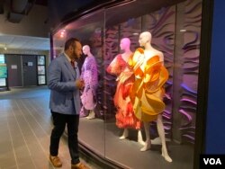 Kepala desain fesyen FIDM Nick Verreos melihat-lihat rancangan Illene Martoseno yang sedang dipajang di kampus FIDM (VOA Maret 2022)