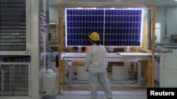 FILE - A worker conducts a quality check of a solar module at a factory in Xian, China, on Dec. 10, 2019. The European Union said on Jan. 24, 2024, that it wants to avoid over-reliance on China, which dominates in green technology production and other industries. 