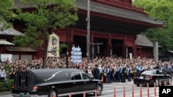 Warga Jepang melepas kepergian mantan PM Shinzo Abe, saat mobil membawa jenazahnya meninggalkan kuil, 12 Juli 2022.