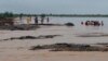 Rescue workers help villagers evacuate from flooded area caused by heavy rains, in the Pakistan district of Lasbela, July 26, 2022. A military helicopter supervising relief efforts went missing on Aug. 1, 2022. 