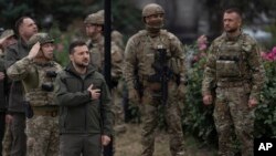 Ukrainian President Volodymyr Zelenskyy takes part in a national flag-raising ceremony in the recently retaken city of Izium, Ukraine, Sept. 14, 2022. 