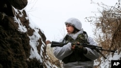A serviceman stands in a trench on the territory controlled by pro-Russian militants near frontline with Ukrainian government forces in Slavyanoserbsk, Luhansk region, eastern Ukraine, Jan. 25, 2022.