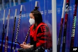 Atlet hoki es Kanada, Melodie Daoust, menggunakan ponselnya di Olimpiade Beijing, China.